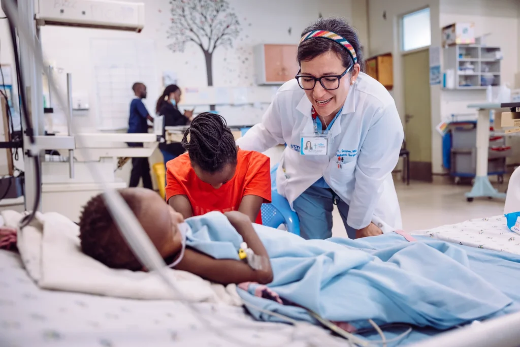 Paediatric doctor caring for a child patient beside a family member